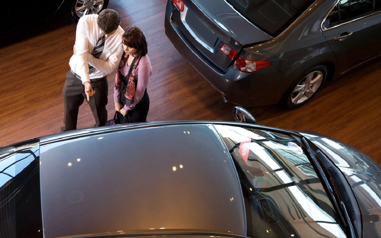 Two people looking at a car in the showroom