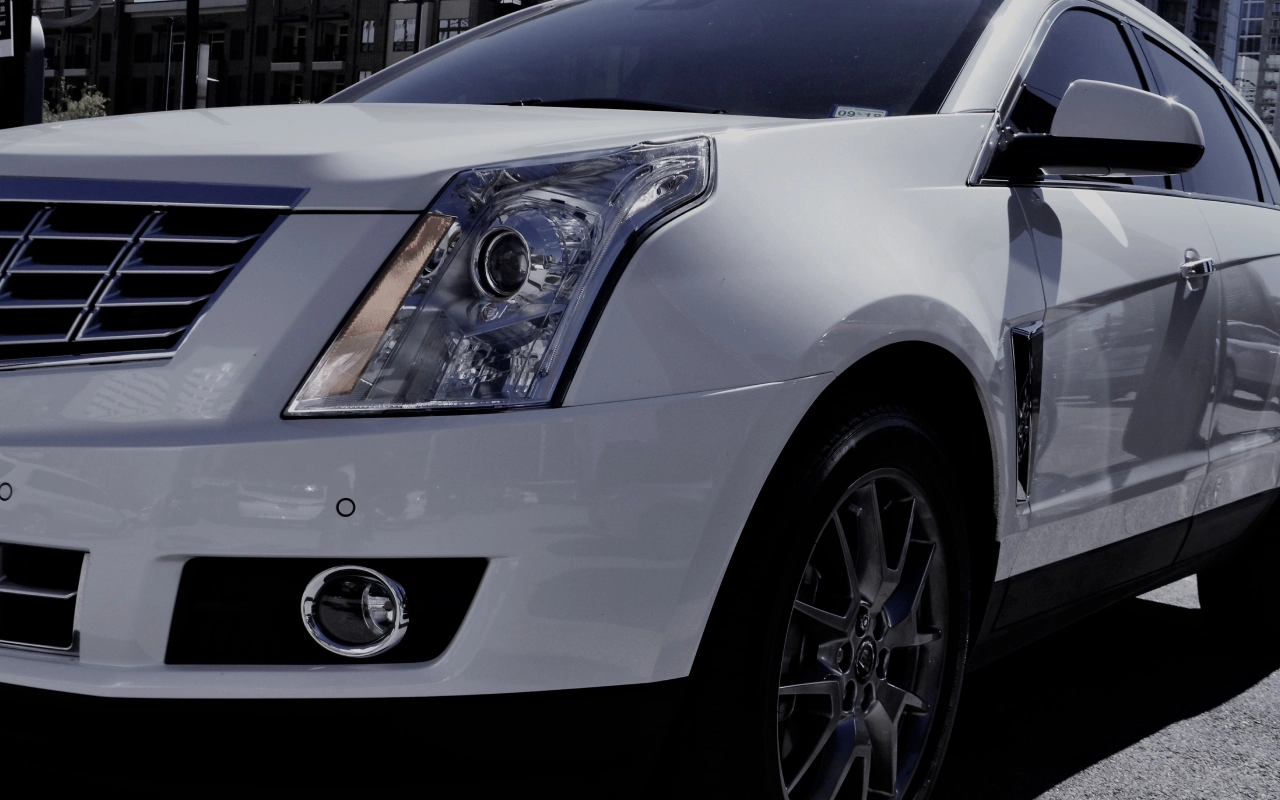 A close up of the front end of a white car.